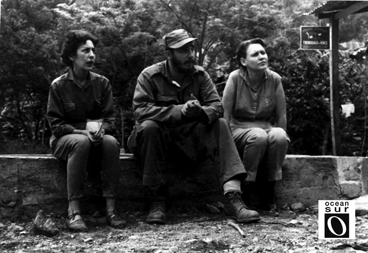 Celia, Fidel y Haydee, sentados en un secadero de café, abril de 1958.